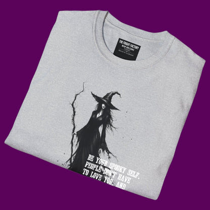Personalized gothic witch graphic t-shirt featuring a detailed illustration of a witch holding a staff, surrounded by the quote 'Be your spooky self. People don't have to love you, and you don't care anyway.' Designed and sold in The Fright Factory NOLA gothic gift shop.
