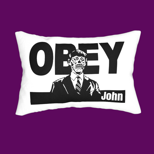 Customizable white 'They Live' movie pillow. The front shows the 'OBEY' subliminal command in black block lettering. A personalized gift for fans of 80s sci-fi and John Carpenter films.