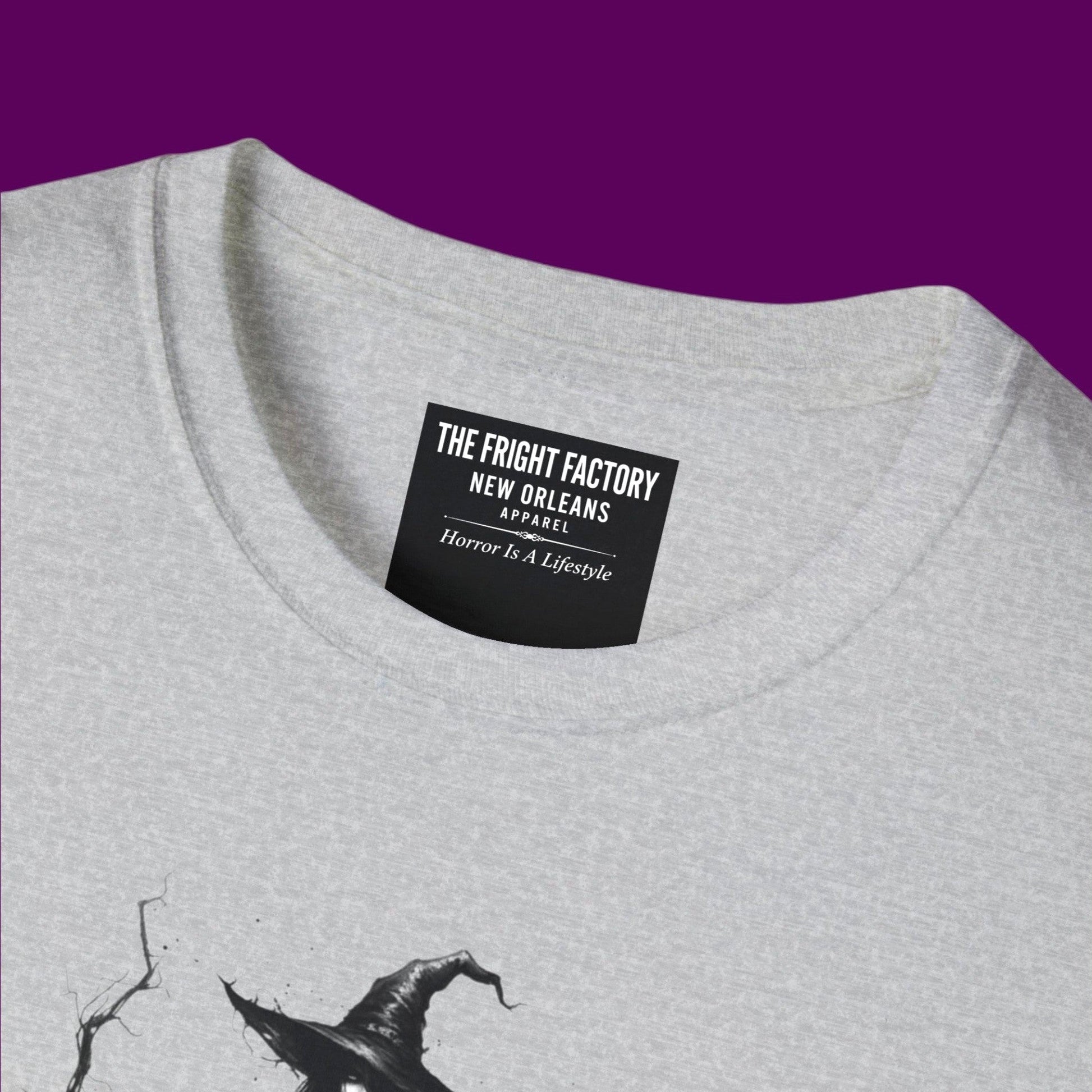 Close-up of colar of a gothic witch graphic t-shirt featuring a detailed illustration of a witch holding a staff, surrounded by the quote 'Be your spooky self. People don't have to love you, and you don't care anyway.' Designed and sold in The Fright Factory NOLA gothic gift shop.