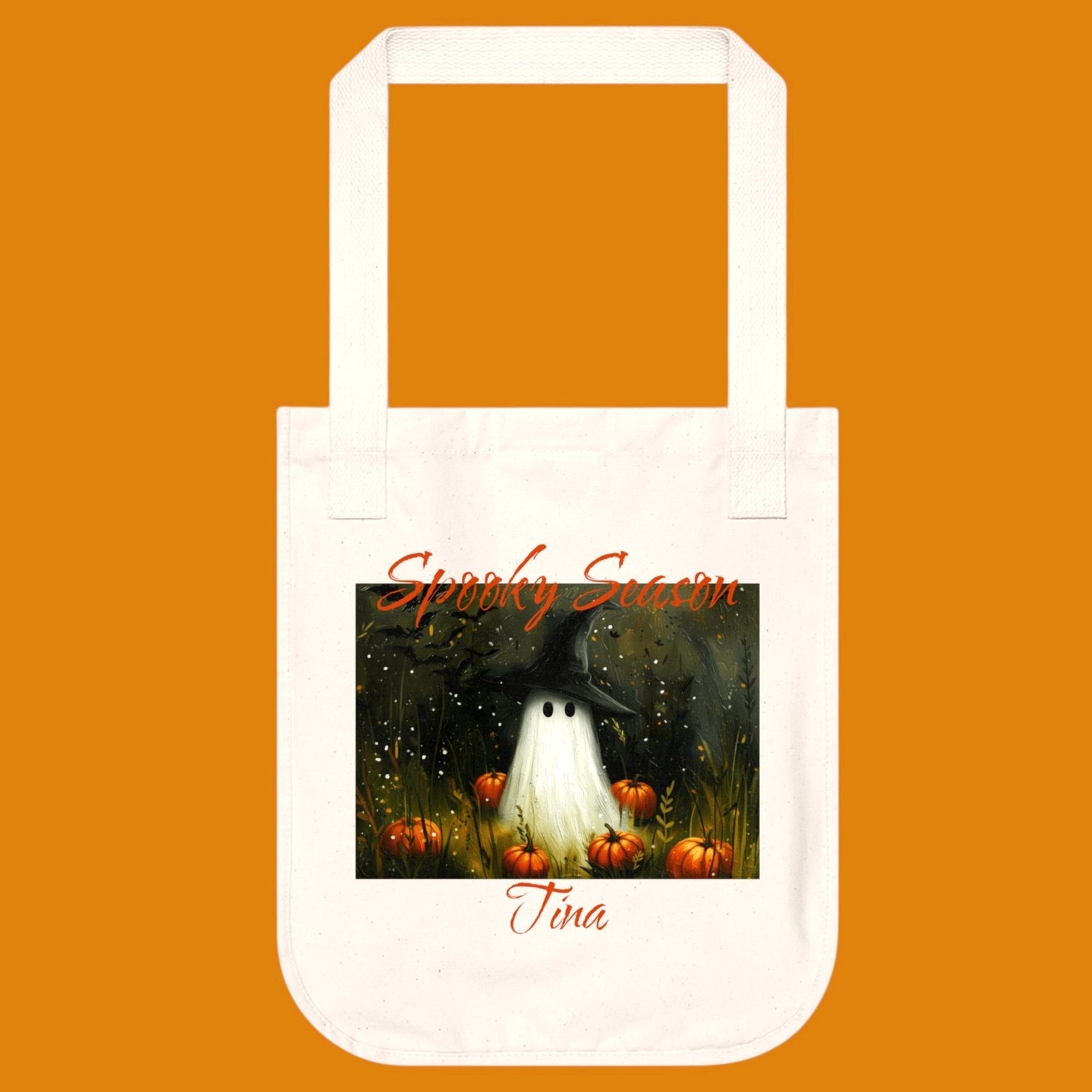 A off white 100% organic cotton tote bag featuring a Halloween-themed illustration of a ghost in a witch hat, surrounded by pumpkins. Personalize yours in The Fright Factory New Orleans horror gift shop.