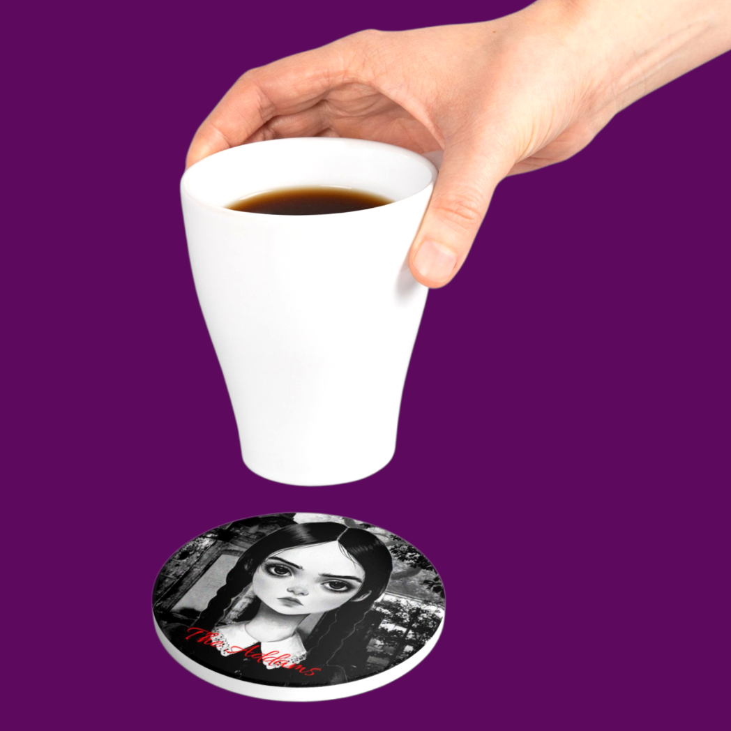 A black coffee mug sitting on a personalized Wednesday Addams gothic coaster on a dark wooden table