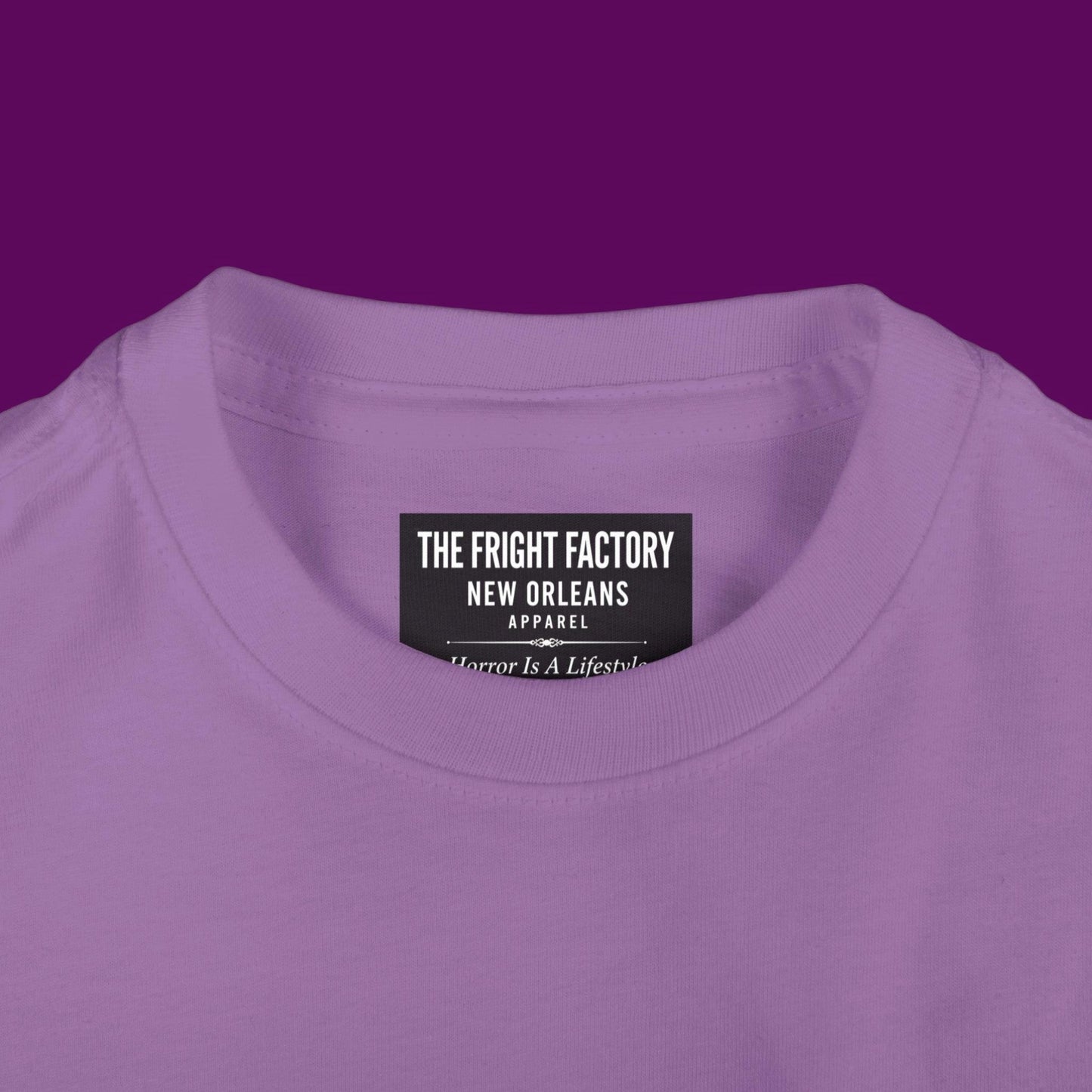 Close-up of a custom Chibi Wednesday Addams inspired goth girl graphic with a personalized name on a purple kids t-shirt. Available in The Fright Factory New Orleans gift shop.