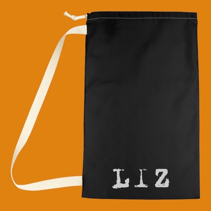"Close up and back side view of a heavy-duty drawstring closure and woven shoulder strap on a sci-fi themed alien laundry bag for college dorm storage. For sale in The Fright Factory New Orleans gift shop.